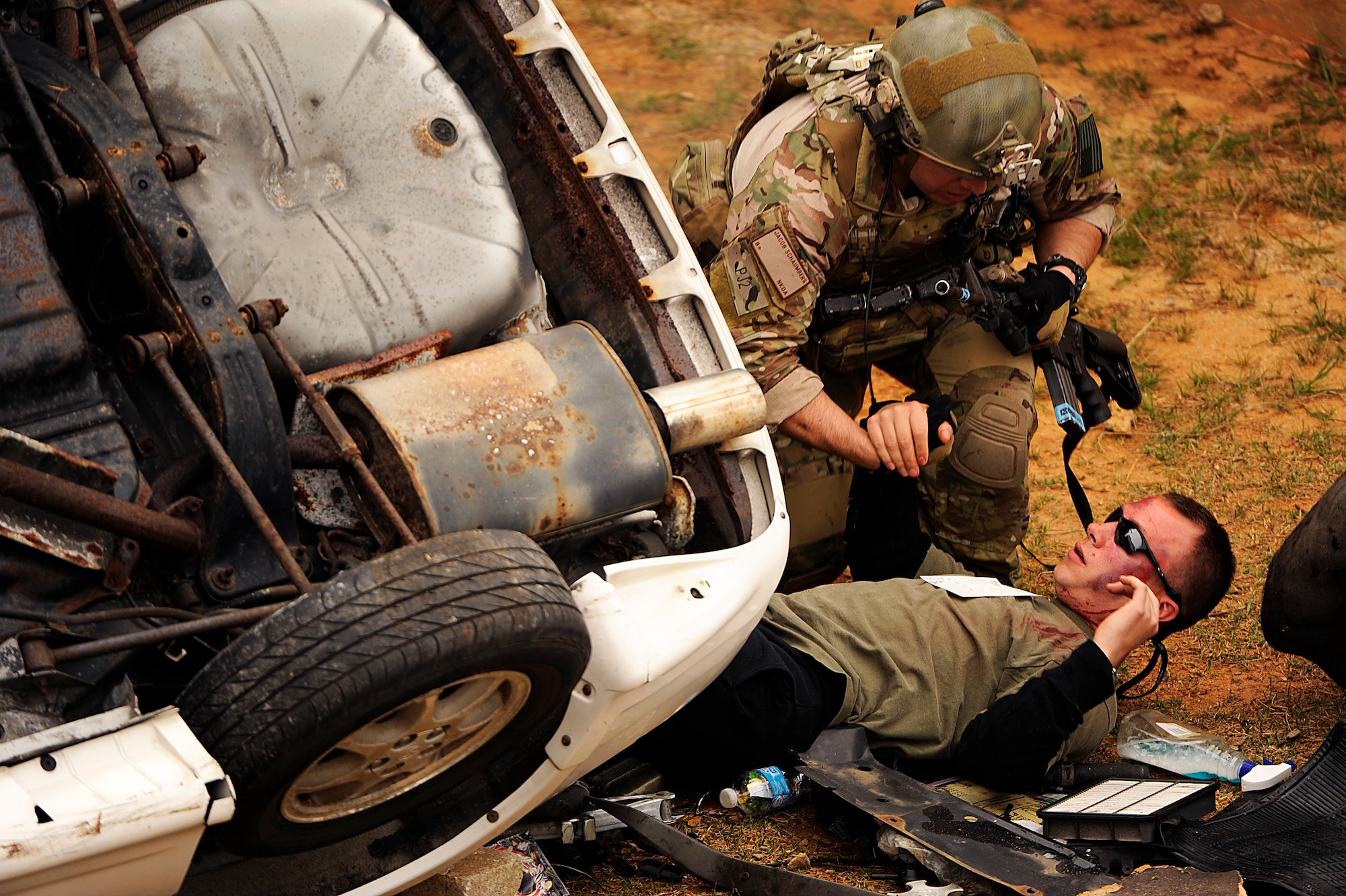 U.S. Air Force Staff Sgt. Jacob Schaumberg, 31st Rescue Squadron pararescueman, pulls a simulated casualty from a flipped vehicle during a war week exercise at Marine Corps Camp Hansen's Combat Town, Japan, Feb. 7, 2013. During the exercise, members from the 31st and 33rd RQSs practiced a multitude of scenarios, including extraction under fire, convoy attacks and aircraft incidents. (U.S. Air Force photo/Senior Airman Maeson L. Elleman)