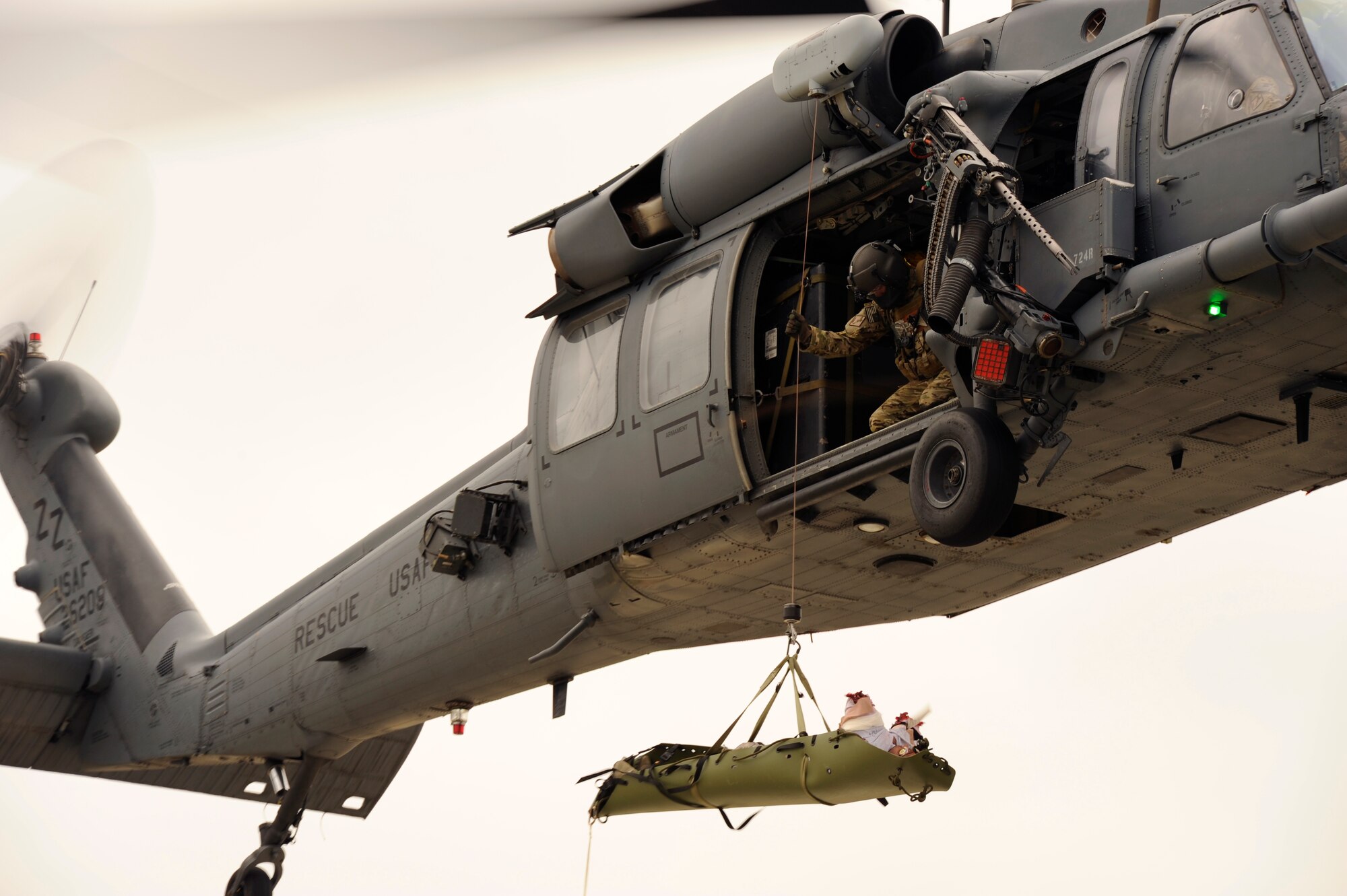 A U.S. Air Force aerial gunner hoists a simulated patient into a 33rd Rescue Squadron HH-60 Pave Hawk helicopter during a war week exercise at Marine Corps Camp Hansen's Combat Town, Japan, Feb. 6, 2013. War week, a three-day pre-deployment exercise, gave members from both of Kadena Air Base's rescue squadrons the opportunity to practice numerous rescue scenarios in a controlled environment. (U.S. Air Force photo/Senior Airman Maeson L. Elleman)