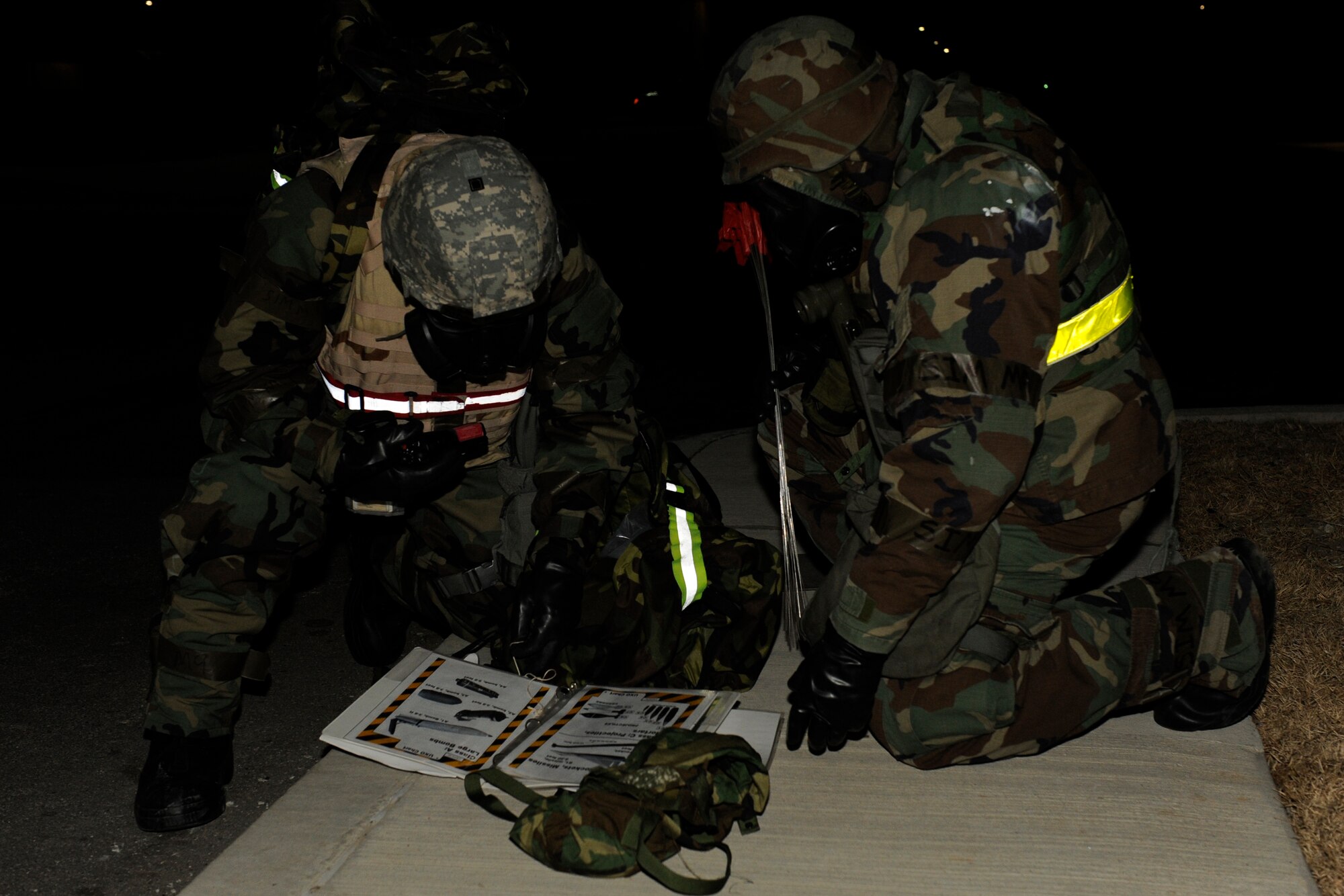 KUNSAN AIR BASE, Republic of Korea -- Senior Airmans Mark Barrett, left, and  Jerrod Floyd, 8th Maintenance Squadron, reference an Airman’s Manual to determine what type of unexploded ordnance was next to their building during exercise Beverly Bulldog 13-2 at Kunsan Air Base, Republic of Korea, Feb. 14, 2013. The Airmen relayed the information to their unit control center as instructed in the Airman’s Manual. (U.S. Air Force photo by Senior Airman Marcus Morris/Released)