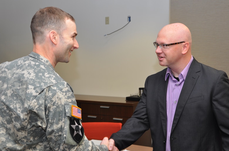 Maj. Patrick Dagon (Left), U.S. Army Corps of Engineers Nashville District deputy commander, presents a challenge coin to Professor Robb Brown, University of Miami-Ohio Dec. 3, 2012 after four of Brown’s graduate students presented architectural designs for a proposed marina at Lake Cumberland, Ky., as part of real-world class assignments.