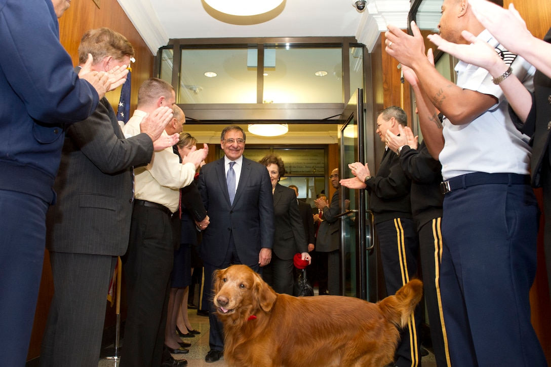Defense Secretary Leon E. Panetta, his wife, Sylvia, and their dog, Bravo, walk through crowds of cheering Defense Department workers and military members at the Pentagon, Feb. 14, 2013. Panetta will remain secretary of defense until his successor is confirmed and sworn in.