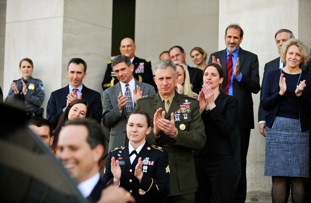 Defense Department workers give Defense Secretary Leon E. Panetta, his wife, Sylvia, and their dog, Bravo, a standing ovation as the secretary departs his office for what was expected to be his last time at the Pentagon, Feb. 14, 2013. Panetta is preparing to retire, but will remain secretary of defense until his successor is confirmed and sworn in.
