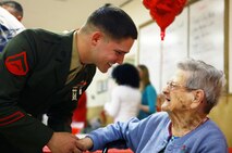 Lance Cpl. Matthew S. Hartlove, a Baltimore native and electrician with 2nd Supply Battalion, 2nd Marine Logistics Group, greets a resident of Carebridge Assisted Living center in Jacksonville, N.C., Feb. 12, 2013. Volunteers from around Camp Lejeune donned their uniforms and invited individual residents to join them on the facility’s dance floor. 