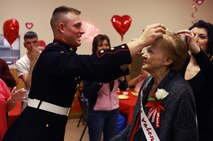 A Marine from Camp Johnson, N.C., puts a tiara on a resident of Carebridge Assisted Living center in Jacksonville, N.C., Feb. 12, 2013. The facility hosted a Sweetheart Dance and invited Marines from various units to dance, sing, eat and socialize with the residents. 