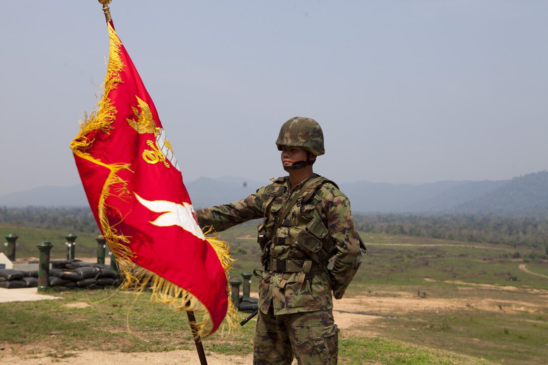 Royal Thai Marine Petty Officer 2nd Class Jatupol Punpara stands at parade rest with his unitâ€™s flag Feb. 11 while waiting the opening ceremony to begin at Ban Chan Krem, Kingdom of Thailand, for exercise Cobra Gold 2013â€™s field training exercises. Cobra Gold is a recurring, multinational and multiservice exercise hosted annually by Thailand and developed by the Thai and U.S. militaries. CG 13 also includes humanitarian and civic assistance projects and a staff exercise. Punpara is an infantryman with 3rd battalion, 1st Infantry, Royal Thai Marines.