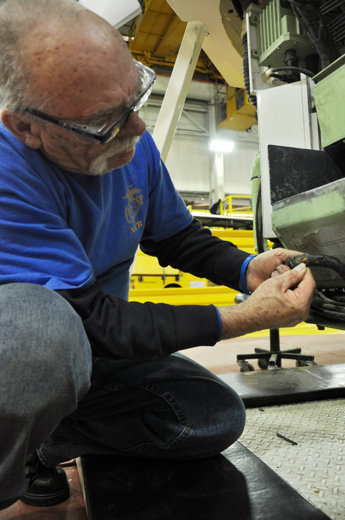Gilmore 'Butch' Grieves, an ordnance mechanic with the artillery shop at Production Plant Barstow, Marine Depot Maintenance Command on Marine Corps Logistics Base Barstow, checks the wiring on the bottom of a LAV-25 turret Jan. 29. Grieves has spent more than 35 years at PPB, a majority of it working on the light armored vehicles.