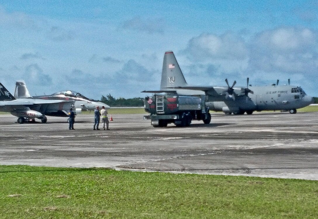 Airmen from the 374th Aircraft Maintenance Squadron and 36th Airlift Squadron, both from Yokota Air Base, Japan, and 36th Logistics Readiness Squadron offload an R-11 refueling truck on the flightline on Rota island, Feb. 13. 2013. Andersen Airmen, along with Airmen from units in support of Cope North 13, transported the R-11 refueling truck to Rota island in order to recover a Navy F/A-18 Hornet that diverted due to weather conditions. (Courtesy photo)