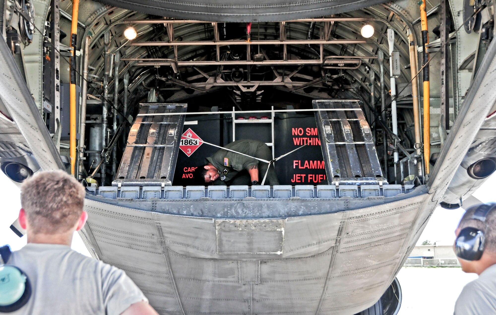 Staff Sgt. Napoleon Ortiz, 36th Airlift Squadron loadmaster from Yokota Air Base, Japan, fastens the ramps onto the C-13 Hercules on the flightline at Andersen Air Force Base, Guam, Feb. 13, 2013. With the combined effort of Airmen from the 374th Aircraft Maintenance Squadron and 36th AS, both from Yokota AB, Japan and currently on Guam for Cope North 13, and the Airmen of the 36th Logistics Readiness Squadron and 734th Air Mobility Squadron, the refueling truck was transported to Rota and successfully refueled a Navy F/A-18 diverted to Rota due to weather conditions. (U.S. Air Force photo by Airman 1st Class Marianique Santos/Released)