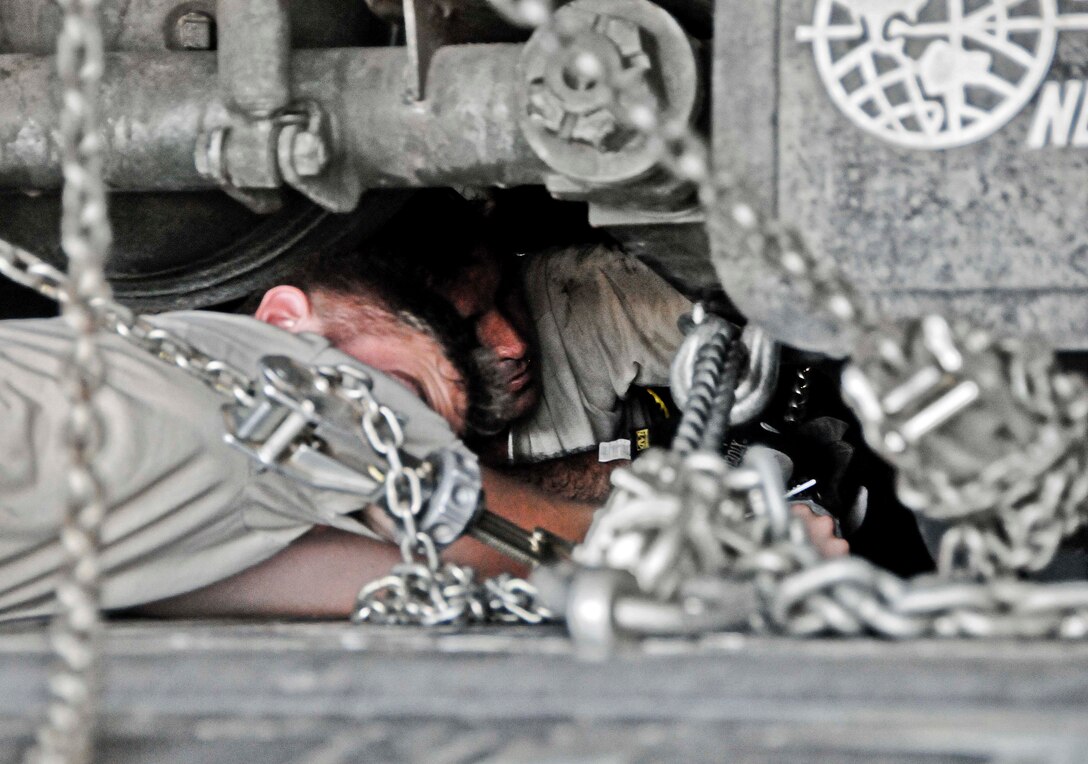Airman 1st Class Kristopher Benfer, 374th Aircraft Maintenance Squadron crew chief from Yokota Air Base, Japan, assists Senior Master Sgt. Matthew Messner, 734th Air Mobility Squadron aerial port superintendent, in securing the bottom of the R-11 refueling truck on a C-130 Hercules. With the combined effort of Airmen from the 374th AMXS and 36th Airlift Squadron, both from Yokota AB, Japan and currently on Guam for Cope North 13, and the Airmen of the 36th Logistics Readiness Squadron and 734th AMS, the refueling truck was transported to Rota and successfully refueled a Navy F/A-18 Hornet diverted to Rota due to weather conditions. (U.S. Air Force photo by Airman 1st Class Marianique Santos/Released)
