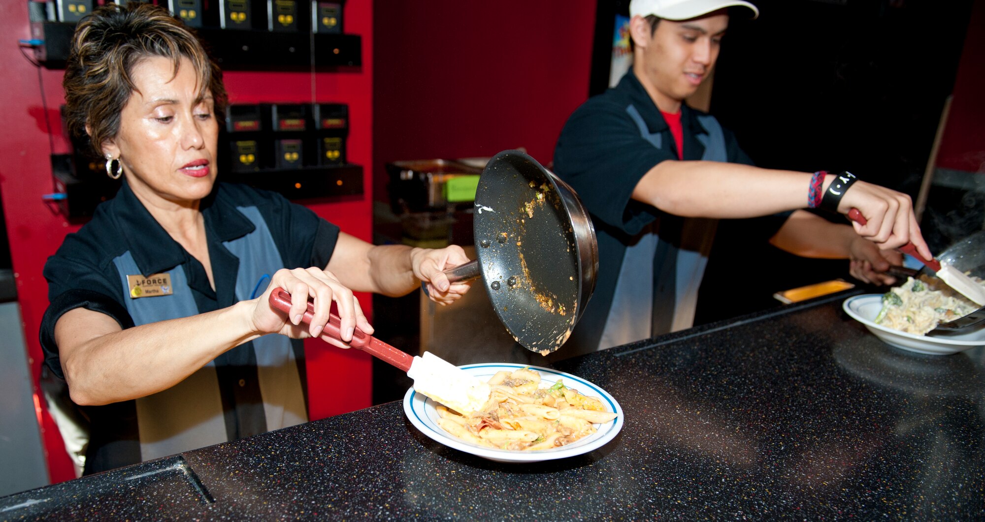Employees of the Desert Sands Enlisted Club serve pasta during the lunch hour at Holloman Air Force Base, N.M., Feb. 15.  While the Raptors Nest is under renovation, the Desert Sands Enlisted Club has taken on many of its services. The pasta bar was one of the most popular additions to the Raptors Nest lunch menu and has been moved to the Desert Sands Enlisted Club during the Raptors Nest renovations. (U.S. Air Force photo by Airman 1st Class Colin Cates/Released) 


