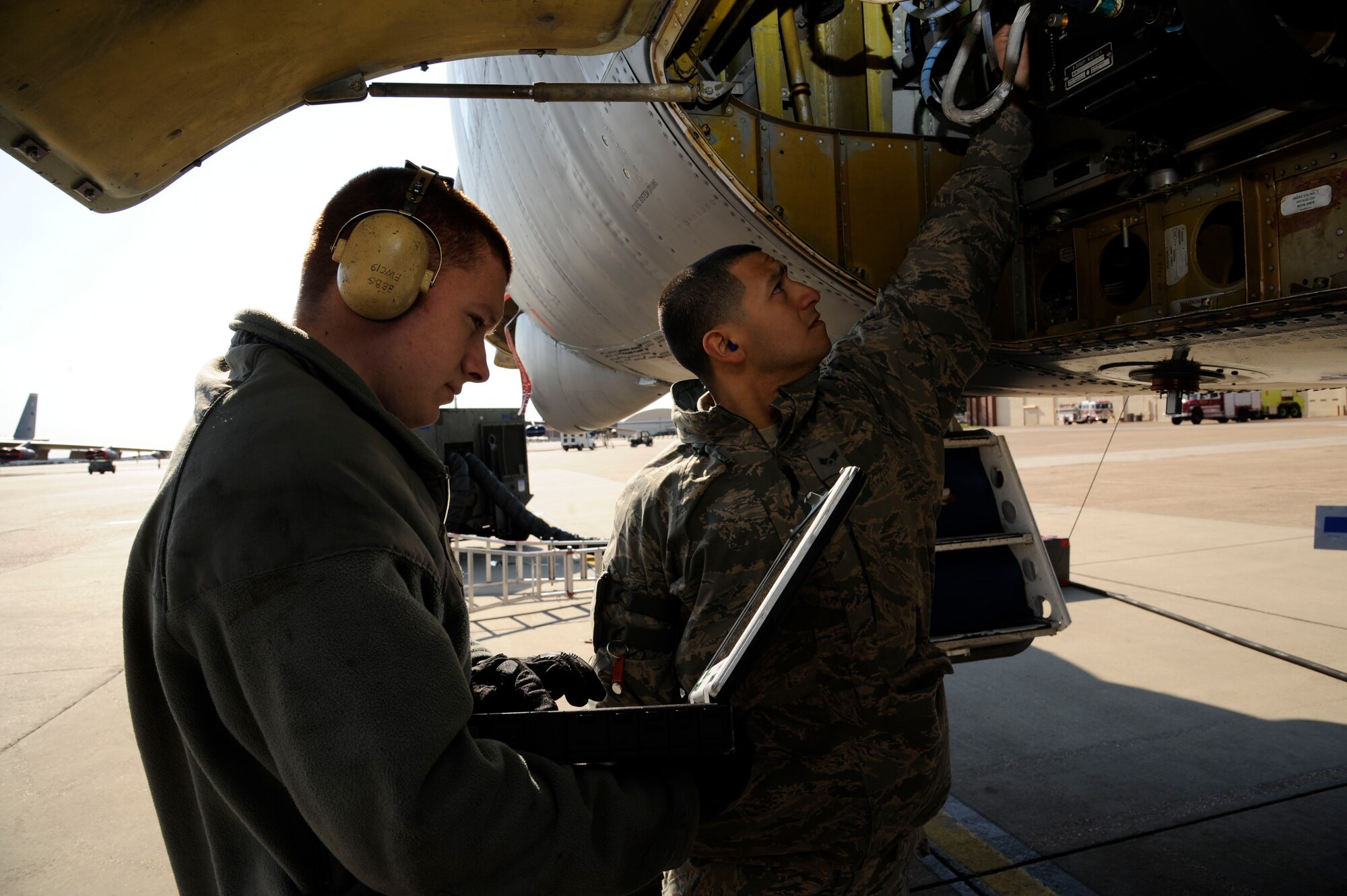 Senior Airman Kevin Rhinehart, 2nd Aircraft Maintenance Squadron, looks over a technical order as Senior Airman Abraham Lopez, 2 AMXS, inspects wiring prior to performing repairs on a B-52H Stratofortress on Barksdale Air Force Base, La., Feb. 15. TO's are step-by-step instruction manuals used by maintenance Airmen that list proper tools needed, any hazards to be aware of and protective gear to accomplish the task. (U.S. Air Force photo/Airman 1st Class Andrew Moua)