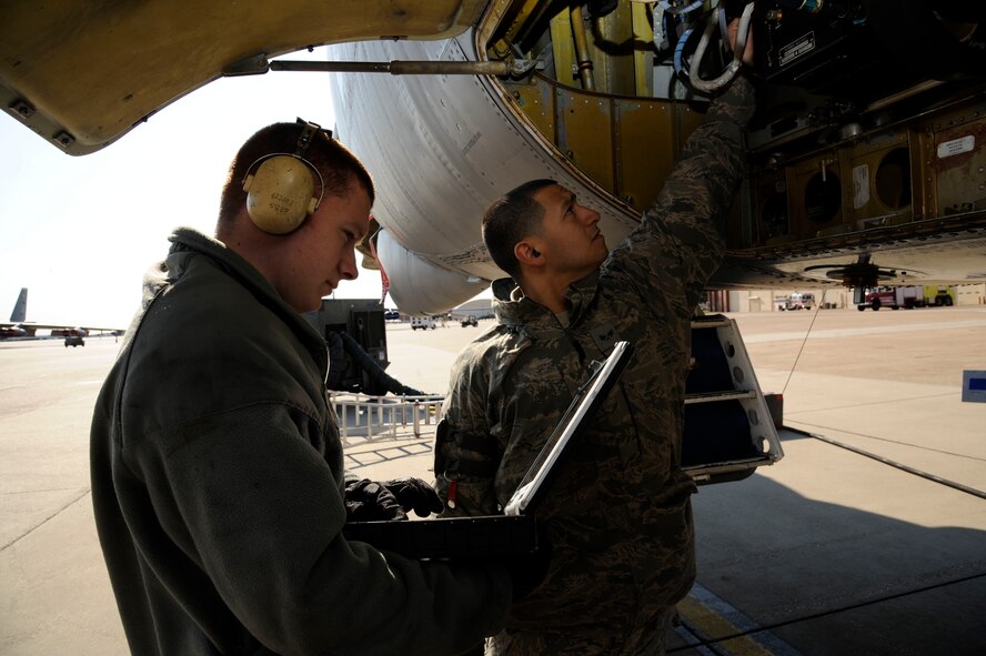 Senior Airman Kevin Rhinehart, 2nd Aircraft Maintenance Squadron, looks over a technical order as Senior Airman Abraham Lopez, 2 AMXS, inspects wiring prior to performing repairs on a B-52H Stratofortress on Barksdale Air Force Base, La., Feb. 15. TO's are step-by-step instruction manuals used by maintenance Airmen that list proper tools needed, any hazards to be aware of and protective gear to accomplish the task. (U.S. Air Force photo/Airman 1st Class Andrew Moua)