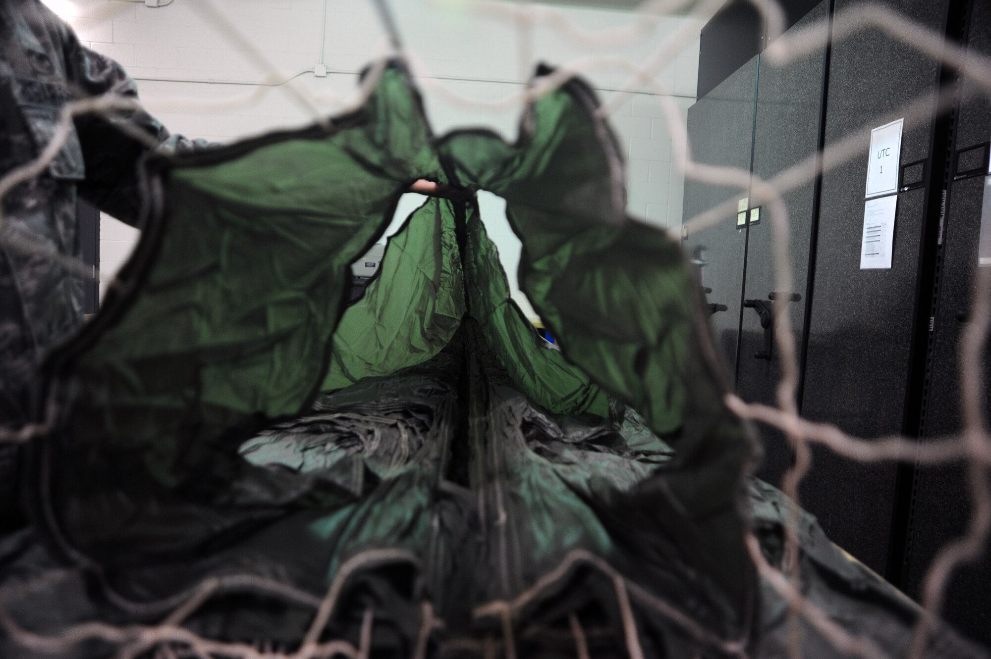 U.S. Air Force Senior Airman James Chapa, 48th Rescue Squadron aircrew flight equipment technician, folds a MC1-1D parachute at Davis-Monthan Air Force Base, Ariz., Feb. 13, 2013. The MC1-1D Parachute should look like a canyon when folded properly. (U.S. Air Force photo by Airman 1st Class Camilla A Griffin/Released)