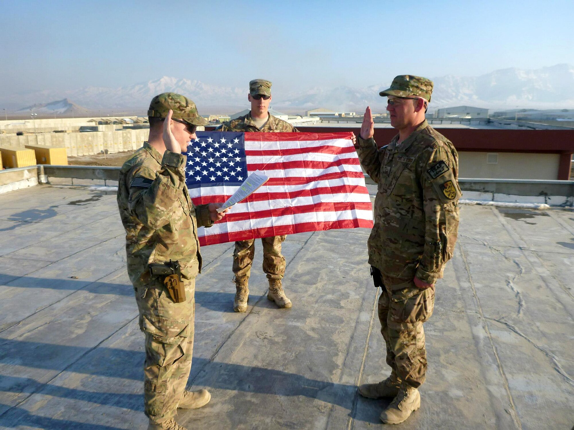 FORWARD OPERATING BASE SALERNO, Afghanistan - Master Sgt. Steven E. Whitesell II (right), 914th Civil Engineering Squadron, Electrical Power Production Supervisor, receives the oath of re-enlistment from Capt. Matthew Heinsler, 914 CES, here February 9, 2013.  Cpl. Ryan Russell held the Colors for the ceremony while Sgt. 1st Class Jan Rachels assisted and took the photo.  Both Whitesell and Heinsler are currently deployed from the Niagara Falls Air Reserve Station, N.Y.  (Courtesy Photo)
