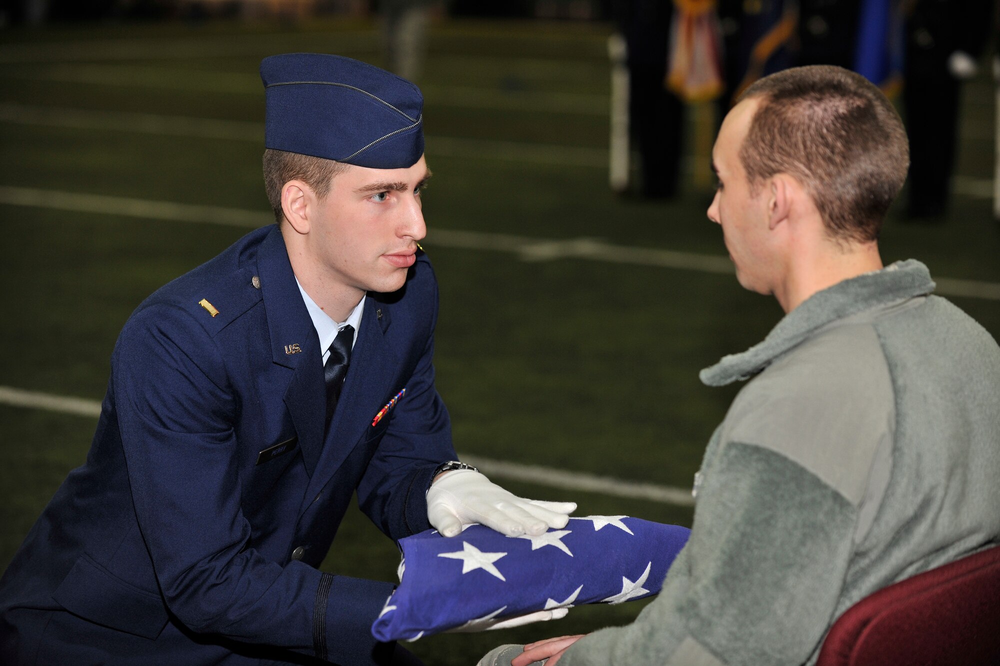 U.S. Air Force 2nd Lt. Shane Perry, 354th Logistics Readiness squadron readiness officer in charge, presents the American flag to Airman 1st Class Jonathon Dipasquale, 354th Logistics Readiness Squadron functional systems manager, as part of a simulated military funeral ceremony during an Honor Guard graduation Feb. 8, 2013, Eielson Air Force Base, Alaska.  Perry’s role involved offering the flag to the next of kin as a symbol of appreciation for the deceased member’s service.  (U.S. Air Force Photo/Senior Airman Racheal Watson)