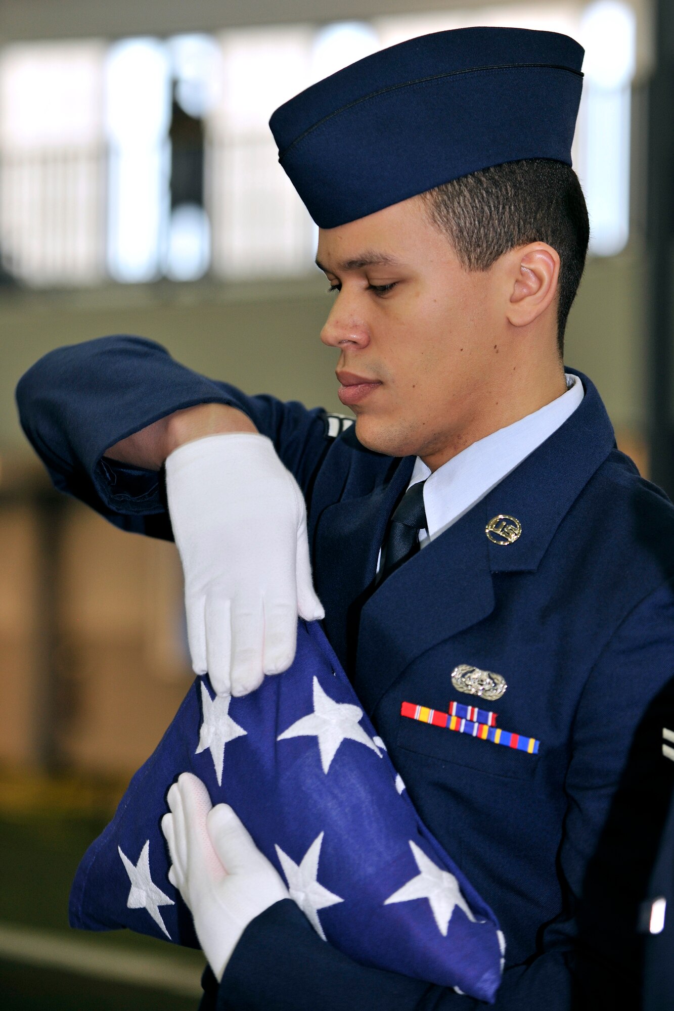 U.S. Air Force Airman 1st Class Timothy Vasquez, 354th Contracting Squadron cyber transport journeyman, folds the American flag during an Honor Guard graduation ceremony Feb. 8, 2013, Eielson Air Force Base, Alaska.  Vasquez participated with 21 Honor Guard graduates in a simulated funeral ceremony.  (U.S. Air Force Photo/Senior Airman Racheal Watson)