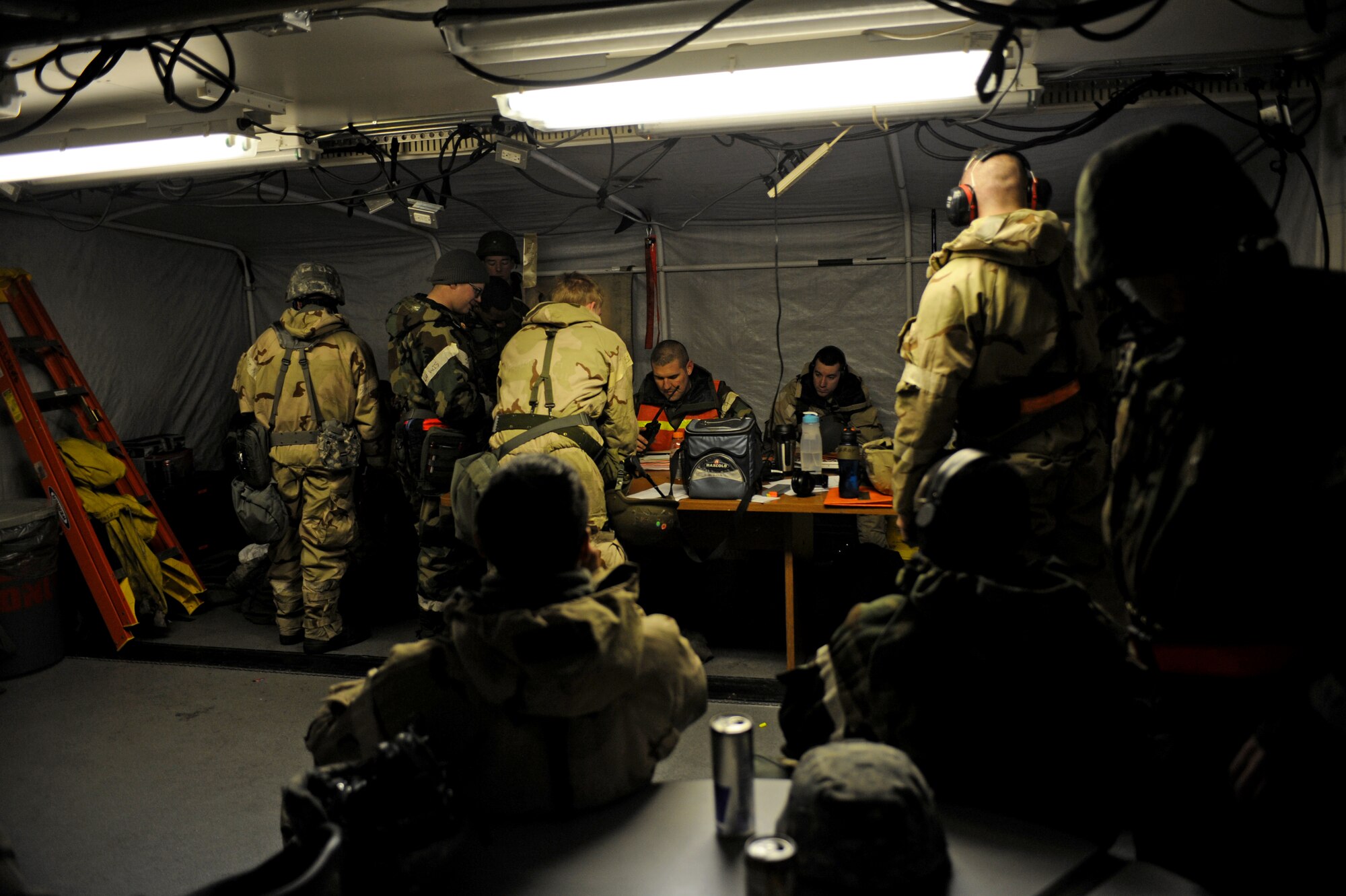 Ground crew members from the 391st Fighter Squadron take shelter inside a tent in preparation for a simulated attack Feb. 14, 2013, at Mountain Home Air Force Base, Idaho. They battled icy winds, single digit temperatures, numerous mechanical problems and issues while wearing extra gear and still made the mission happen. (U.S. Air Force photo/Senior Airman Benjamin Sutton) 