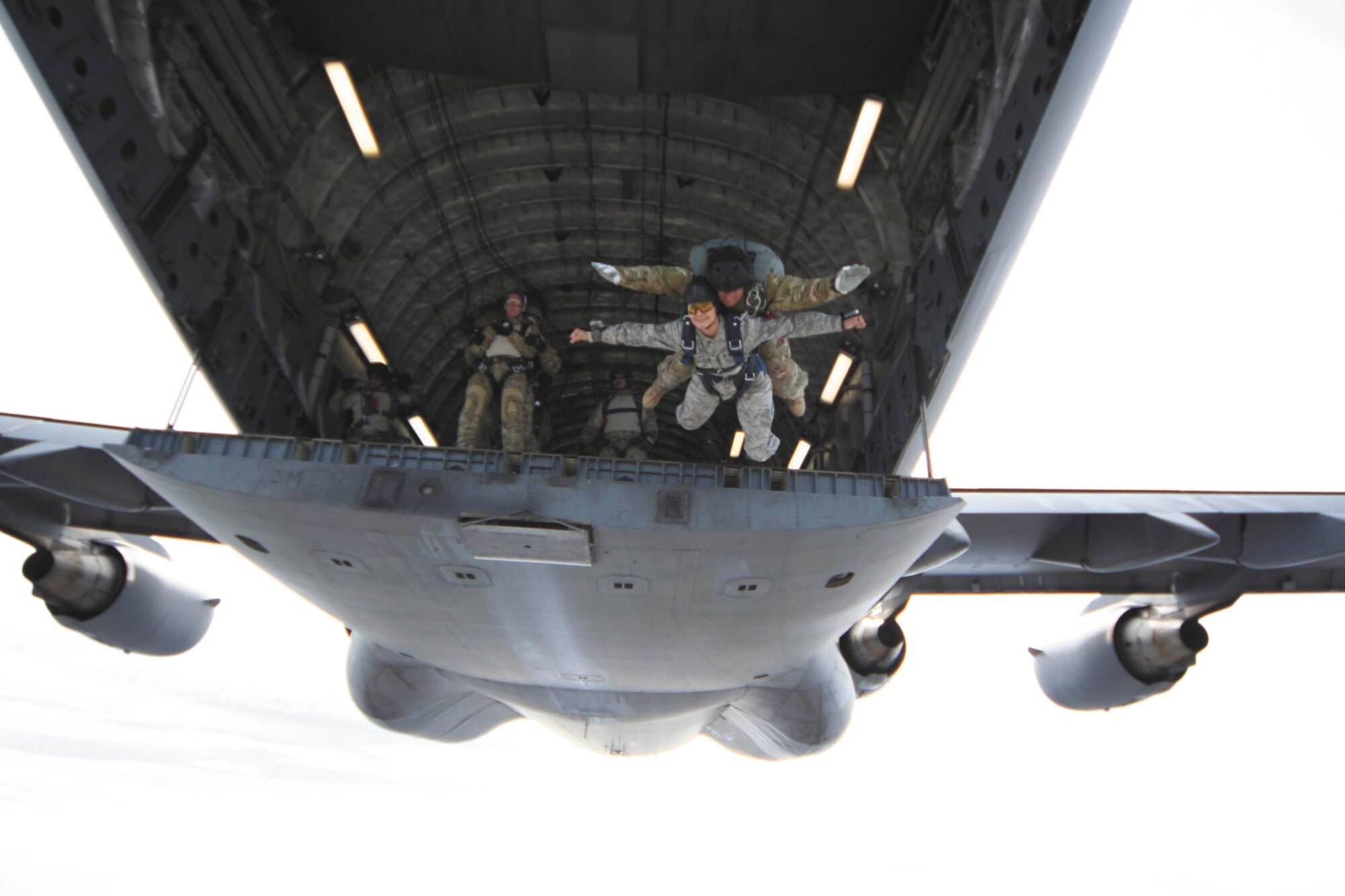 Staff Sgt. Victoria Lopez jumps in tandem with Kirby Rodriguez from a C-17 at 10,000 feet. Lopez is an executive assistant with the 37th Training Group and Rodriguez is a tandem master jumper and personnel parachute program manager with the 342nd Training Squadron. Still in the aircraft and waiting to jump is Senior Master Sgt. Jason Lydon with his tandem passenger Senior Airman Chris Lewis.  (U.S. Air Force photo by Tech. Sgt. Marc Esposito)