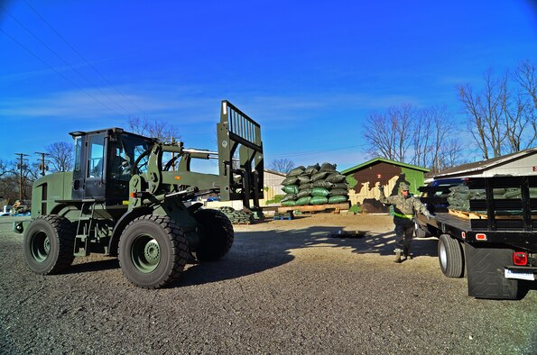 WRIGHT-PATTERSON AIR FORCE BASE, Ohio - Master Sgt. Alan Baker, structural craftsman, guides Master Sgt. John Murphy, pavements and construction technician, as he loads sandbags onto a flat bed truck Jan 20. Both are from the 445th Civil Engineer Squadron. (U.S. Air Force photo/Staff Sgt. Mikhail Berlin)