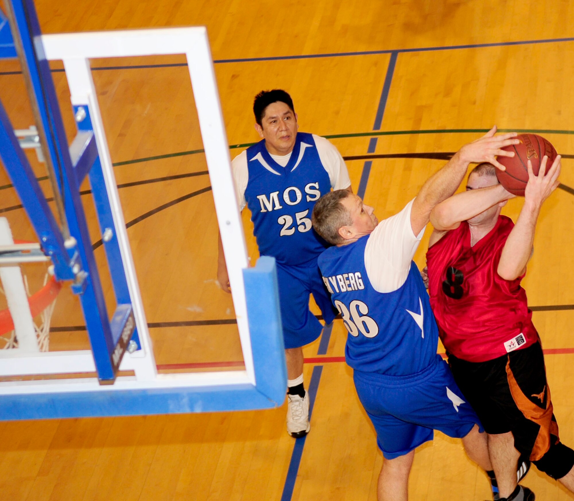 Staff Sgt. Bruce Shoffner, 100th Comptroller Squadron finance customer service team lead from Houston, Texas, takes a jump shot while being blocked by Staff Sgt. Travis Skyberg, the 100th Maintenance Operations Squadron engine manager from Desmet, S.D., during an intramural basketball game Feb. 14, 2013, at the Hardstand Fitness Center, RAF Mildenhall, England.   The 100th Force Support Squadron played against the 100th MOS with the 100th MOS winning the game 41-23. (U.S. Air Force photo by Senior Airman Ethan Morgan/Released