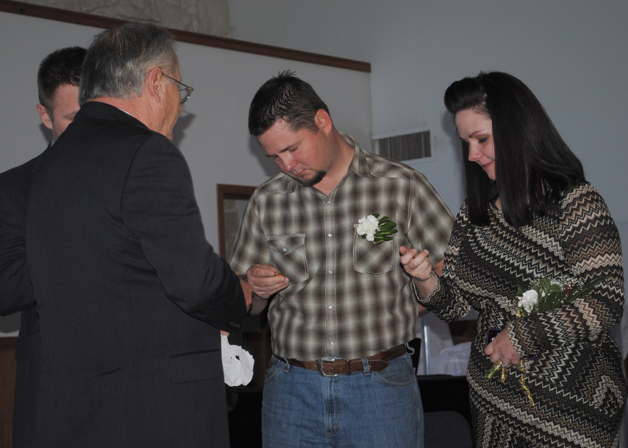 Dennis Ellingson gives his children a 24-karat gold-plated silver dollar, which symbolizes his “golden wedding anniversary,” he said at his vow renewal ceremony.  Dennis married his wife Jacque on Feb. 8, 1963, at the Malmstrom Chapel.  (U.S. Air Force photo/Senior Airman Cortney Paxton)