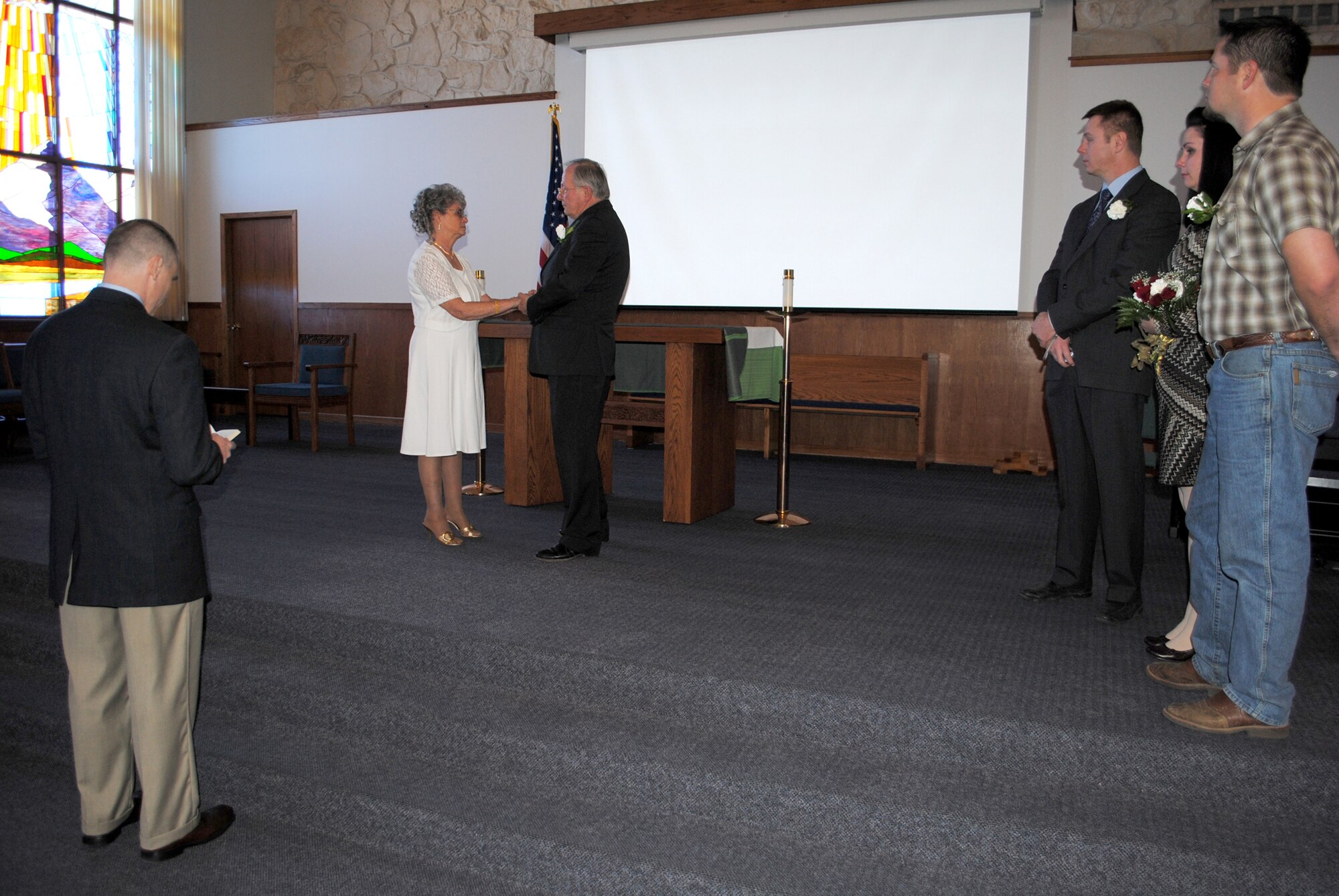 Chaplain (Capt.) Robert Compere, 341st Missile Wing chaplain, far left, officiates Jacque and Dennis Ellingson’s vow renewal ceremony Feb. 8 at the base chapel.  Three of the couple’s five children flew into Montana to witness the ceremony; pictured from left to right are Army Capt. Edward Ellingson, Alena Ward and Eric Ellingson.  (U.S. Air Force photo/Senior Airman Cortney Paxton)