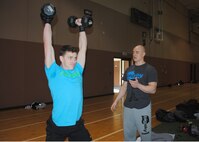 Senior Airman Joshua Minson, 341st Security Forces Group member, completes 25 push-presses in round two of the Warrior-Fit Competition, as Staff Sgt. Christian Nichols, 341st Force Support Squadron Airman Leadership School instructor, counts his repetitions. 14 members of Team Malmstrom participated in the competition, based on CrossFit exercises. (U.S. Air Force photo/Airman 1st Class Katrina Heikkinen)