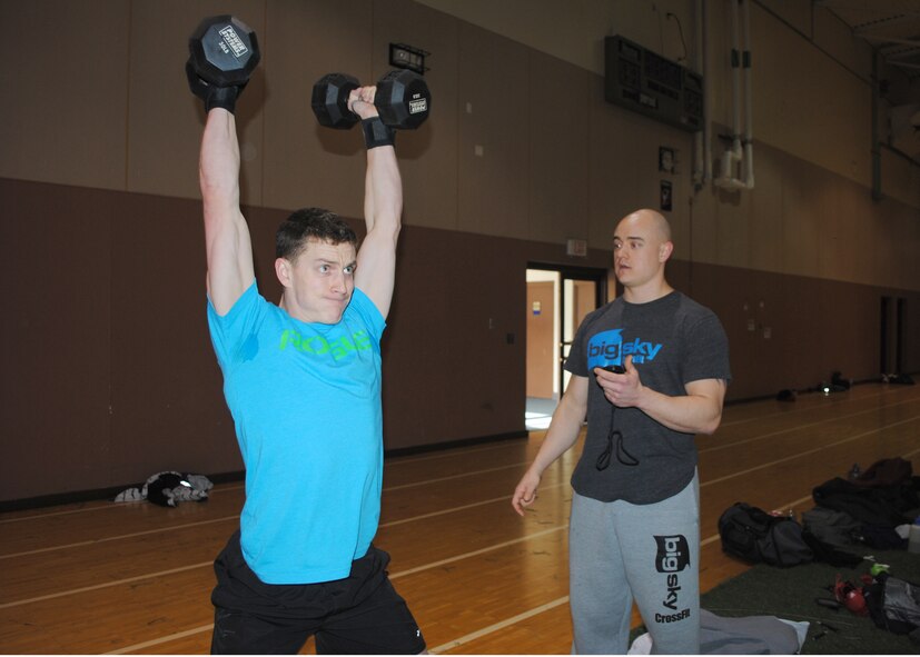 Senior Airman Joshua Minson, 341st Security Forces Group member, completes 25 push-presses in round two of the Warrior-Fit Competition, as Staff Sgt. Christian Nichols, 341st Force Support Squadron Airman Leadership School instructor, counts his repetitions. 14 members of Team Malmstrom participated in the competition, based on CrossFit exercises. (U.S. Air Force photo/Airman 1st Class Katrina Heikkinen)