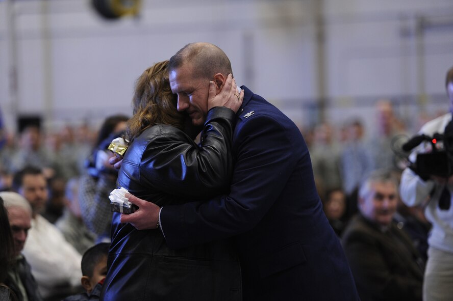 Col. Robert Stanley, newly appointed 341st Missile Wing commander, presents his wife, Cheryl, with a gift and embraces her after publicly thanking her for her support. Stanley addressed the audience, during his change of command ceremony Feb. 8 at the 3-Bay Hangar, by first thanking those closest to him for their love and support. (U.S. Air Force photo/Airman 1st Class Katrina Heikkinen)
