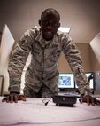 Senior Airman Evens Perjuste, 47th Civil Engineer Squadron, poses for a photo at his office desk in the 47th CES building at Laughlin Air Force Base, Texas, Jan. 30, 2012. Perjuste was born in Haiti and came to America in 2000. He became a U.S. citizen in 2011, a year after enlisting in the Air Force. (U.S. Air Force photo/Senior Airman Nathan Maysonet)