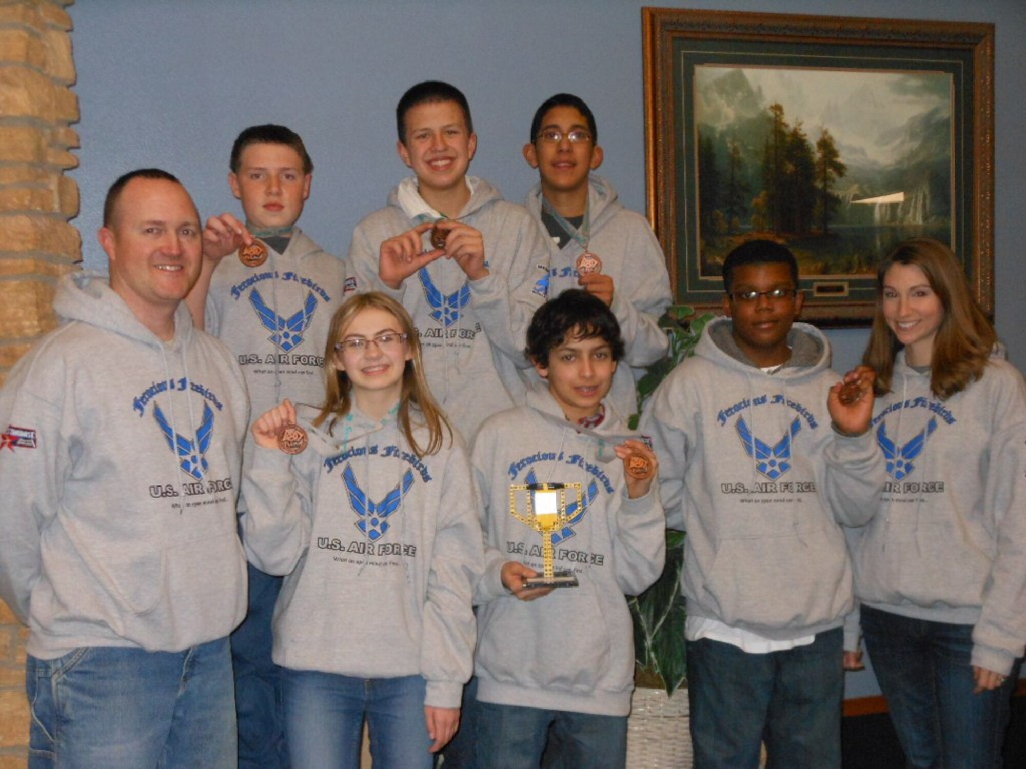 MINOT AIR FORCE BASE, N.D. -- The Ferocious Firebirds display their trophy and medals won during a FIRST LEGO League team competition held recently in Grand Forks, N.D. The team of students from Memorial Middle School won first place for Teamwork. Their winning Lego robotics design was an idea to make driving safer for the elderly. (Courtesy photo)