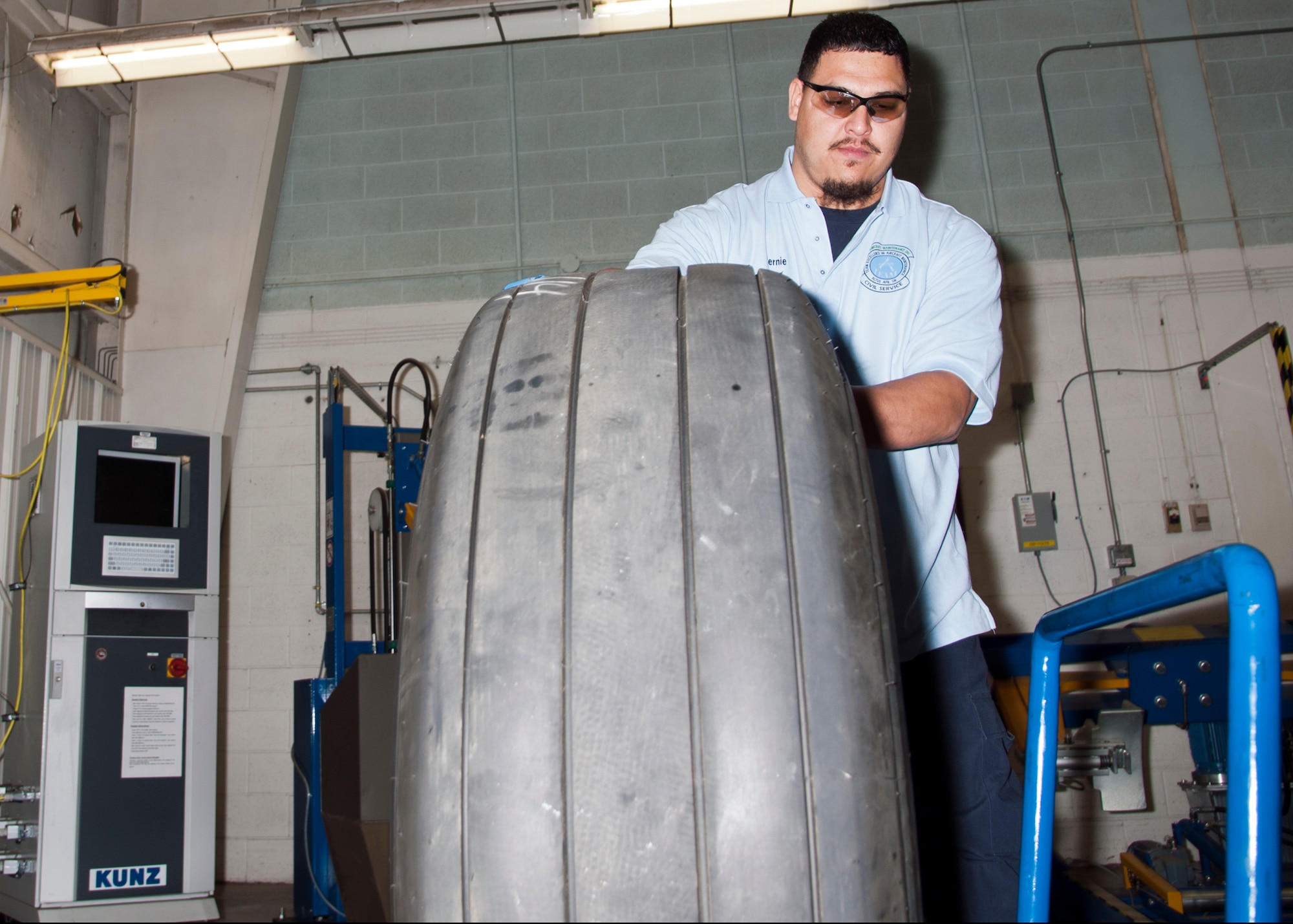 ALTUS AIR FORCE BASE, Okla. -- Bernabe Mejorado Jr., 97th Maintenance Directorate work leader, rolls a tire into a tire-rack, Feb. 12, at one of the 97th MX's back-shops. Mejorado is an aircraft technician who completed the Grow Your Own Mechanic program and has been working in the 97th MX full-time for three years. The GYOM program is an aircraft maintenance technician internship program. It was developed in 1999 under the Student Education Employment Plan in cooperation with the Southwest Technology Center’s Aviation and Aerospace program, providing aerospace jobs to the local area. (U.S. Air Force photo by Senior Airman Kenneth W. Norman / Released)