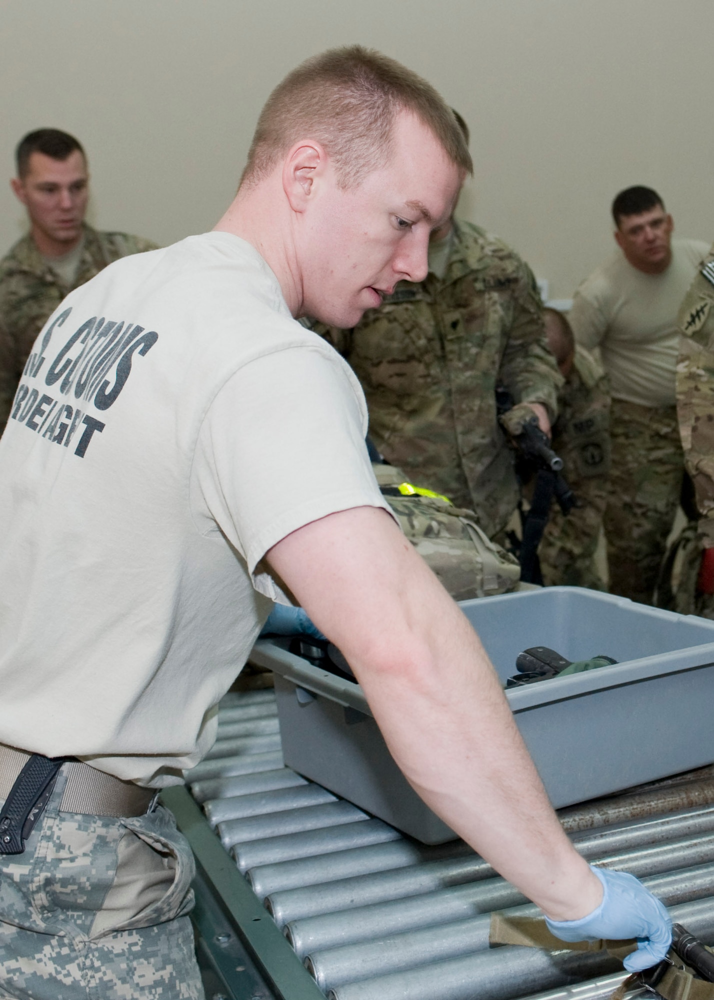U.S. Army Cpl. Zachary Brooker, 304th Military Police Battalion Detachment 5 customs and border patrol agent, inspects personal items prior to sending them through an x-ray machine Feb. 14, 2013, at Transit Center at Manas, Kyrgyzstan. Similar to a commercial airport, passengers and bags are scanned for prohibited items. Brooker is deployed from Nashville, Tenn., and is a native of Murfreesboro, Tenn. (U.S. Air Force photo/Staff Sgt. Stephanie Rubi)