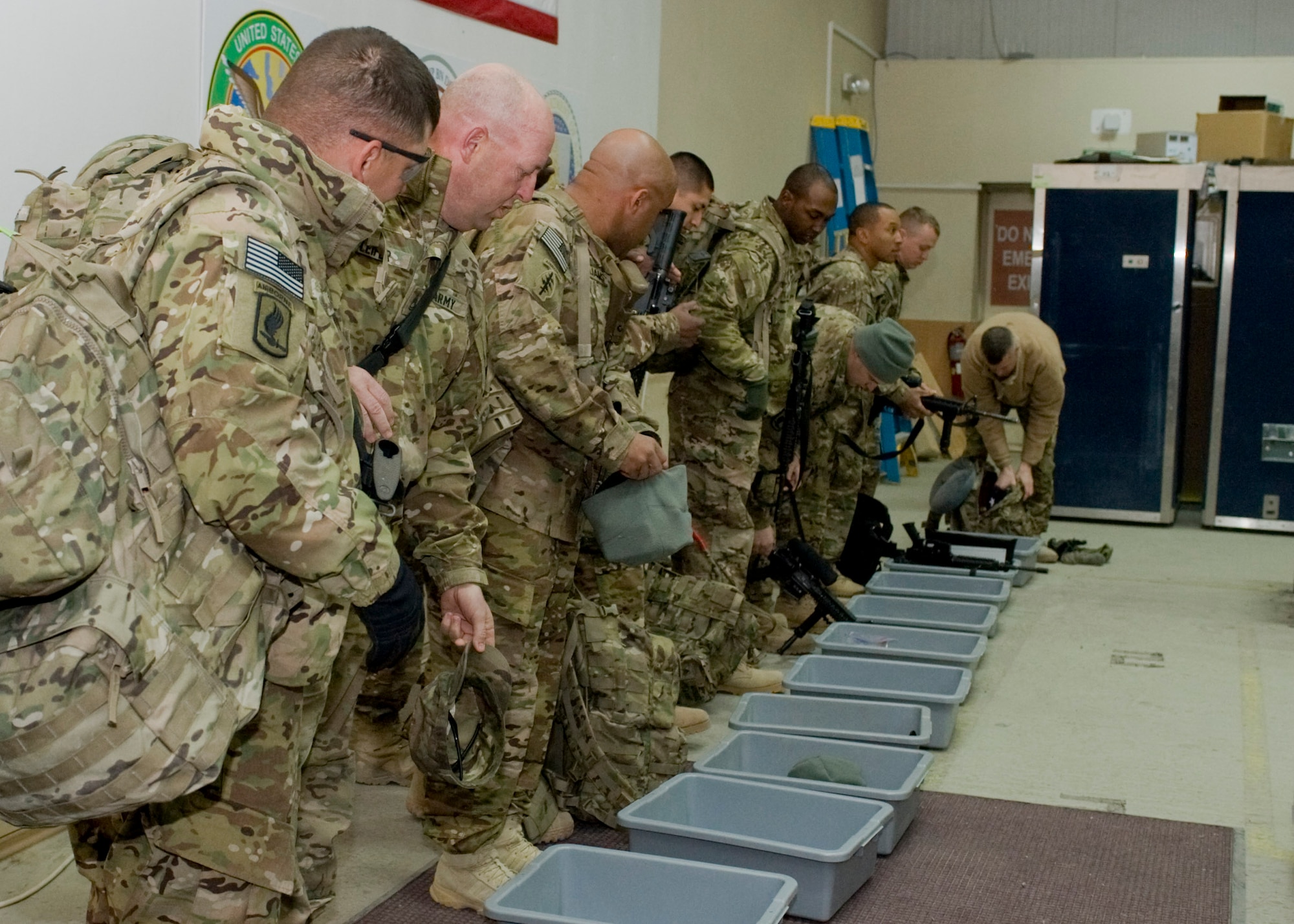 U.S. Soldiers line-up behind bins while processing through the 376th Expeditionary Customs Processing Office Feb. 14, 2013, at Transit Center at Manas, Kyrgyzstan. U.S. service members and their bags are thoroughly screened for prohibited items; once screened passengers are given customs declaration forms and moved to a holding area where they wait for their flight to depart. (U.S. Air Force photo/Staff Sgt. Stephanie Rubi)