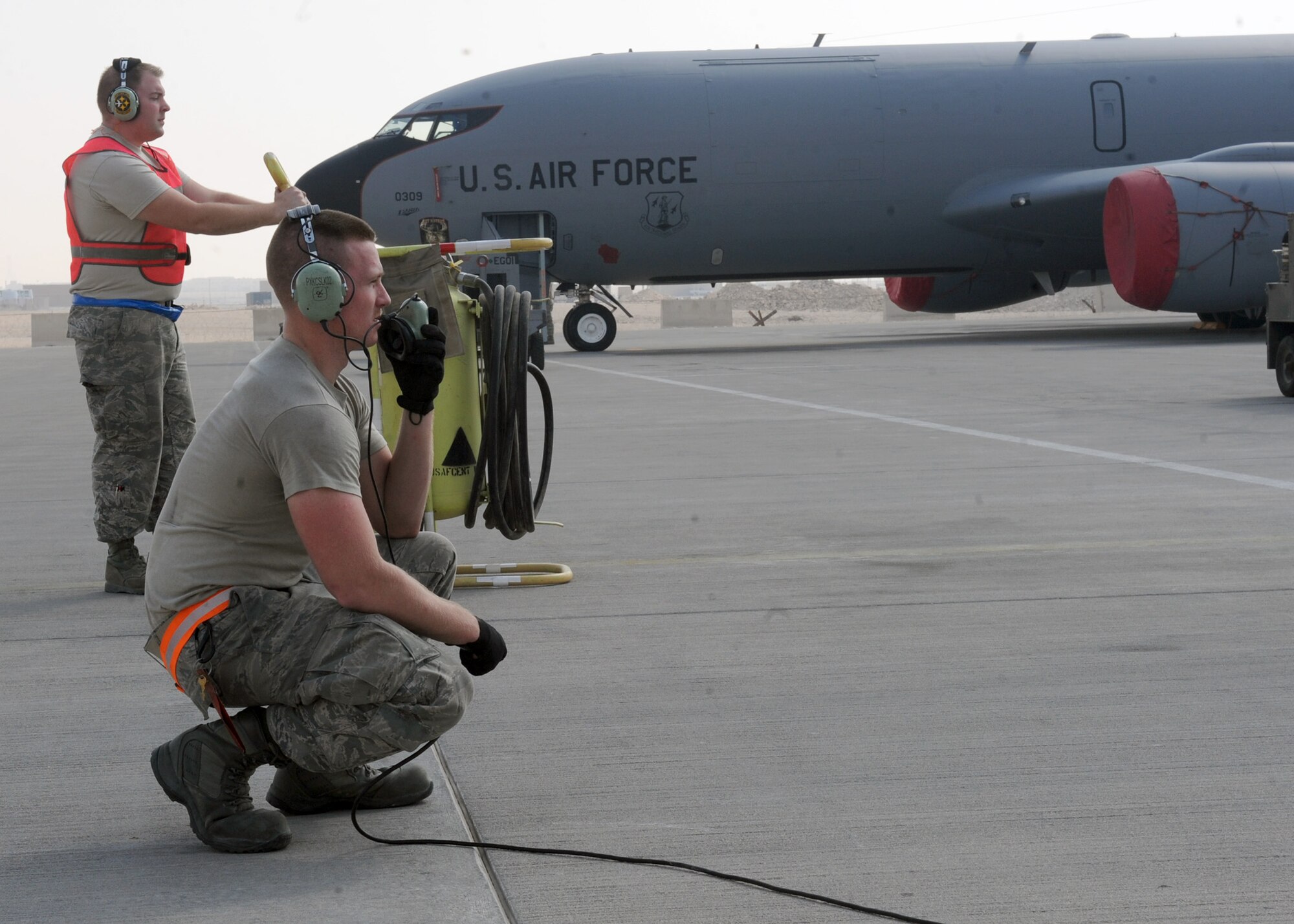 SOUTHWEST ASIA - From left, Tech. Sgt. Josh Vargo and Airman First Class Jarred Purvis watch an engine run before a KC-135 taxis from the ramp Feb. 13. Vargo is a ground fire safety observer for an engine start during preflight checks. Purvis is providing real time on ground communication with aircrew to verify proper responses to flight control checks and engine start sequence. Vargo and Purvis are both electricians assigned to the 340th Aircraft Maintenance Unit. Vargo is deployed from the 171st Air Refueling Wing in Pittsburg, Penn. Purvis is deployed from the 911th Air Refueling Squadron at Seymour Johnson Air Force Base, N.C. (U.S. Air Force photo by Senior Airman Joel Mease)