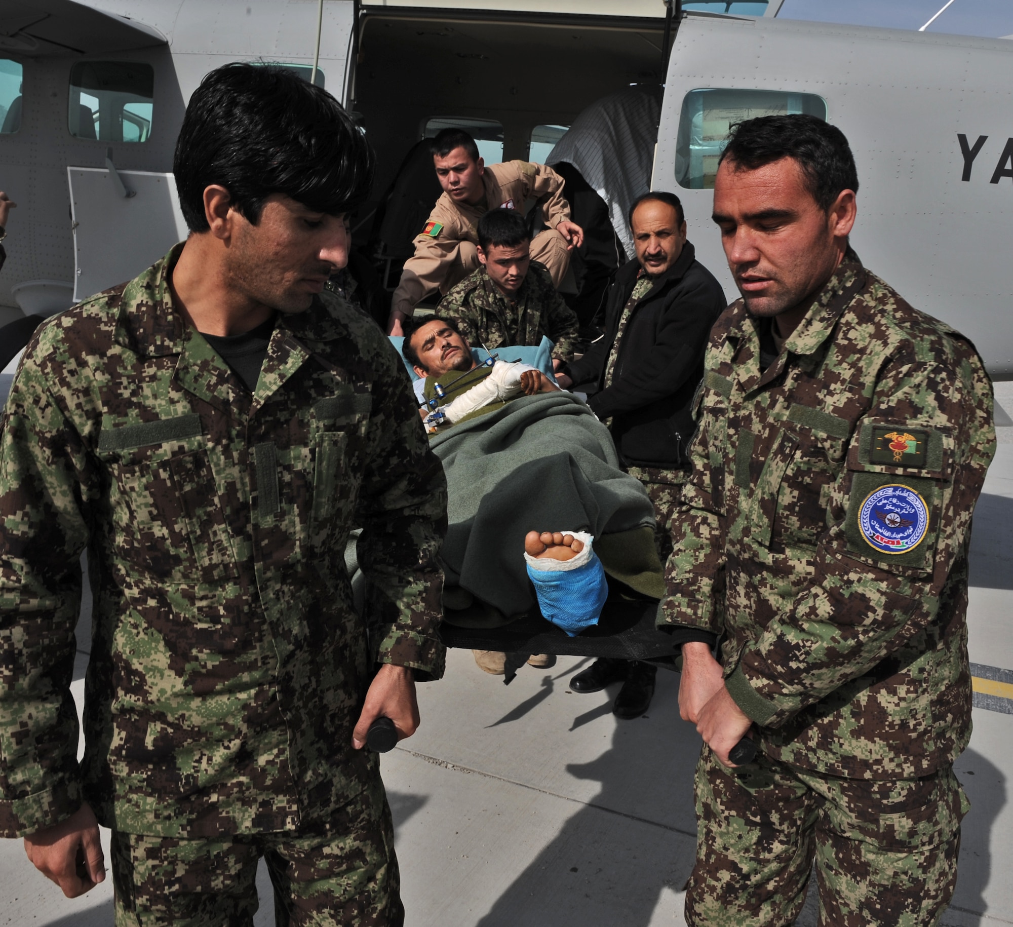KABUL, Afghanistan -- Flight nurses from the Afghan Air Force Clinic in Kabul, assisted by the AAF Surgeon General, Col. Abdul Rasoul Mayel, lift the first litter borne patient in Afghan Air Force history transported by a Cessna 208, off the aircraft in Kabul, Feb. 11, 2013.  (438 AEW Public Affairs photo/Sgt Vaughan Lightowler, Canadian Forces Combat Camera)