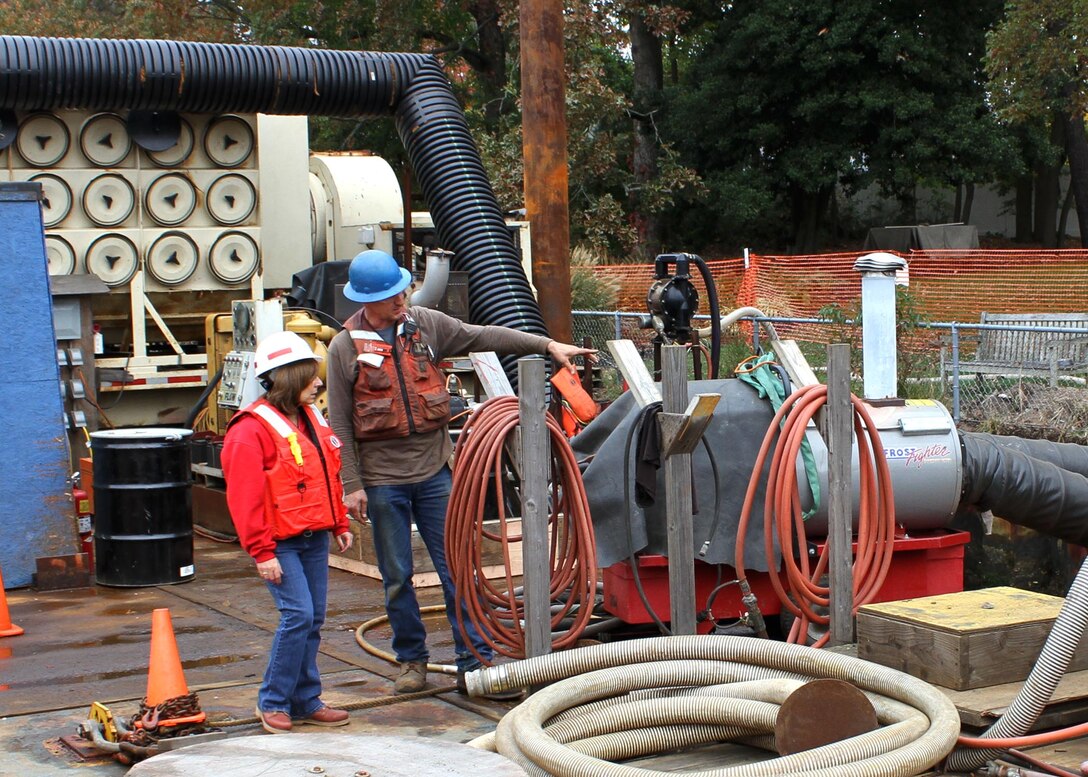 Rudy Sorrells, an inspector for Abhe & Svoboda, speaks with Monica Chasten, a project manager for the U.S. Army Corps of Engineers Philadelphia District. Sorrells explains the operation of a desalination station used to produce freshwater for an ultra-high pressure wash of the steel bulkhead along the Point Pleasant Canal.