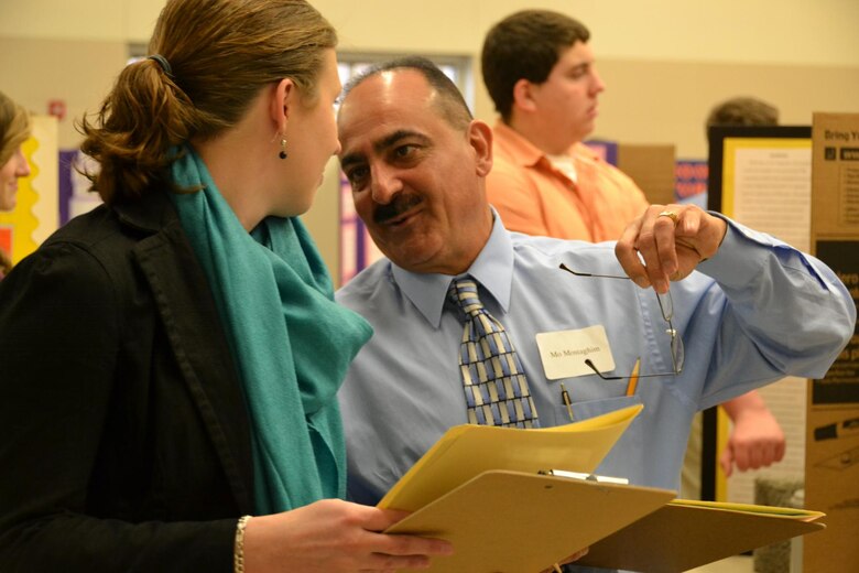 Middle East District's Mo Mostaghim confers with another judge during the annual science fair.