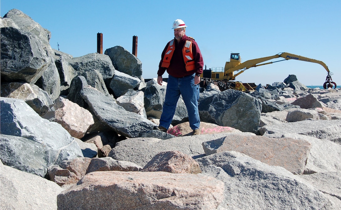 Bob Keistler, project manager of the Masonboro Inlet South Jetty Repair Project, inspects an area where large rocks have been placed by contractors to reinforce the jetty. The eastern most part of the jetty has actually sunk into the ocean floor because of currents and constant pounding by waves. The new layer of rocks will increase its effectiveness and help to stabilize it. Originally built in 1980, the south jetty helps ensure safe passage for private, commercial and Coast Guard boats and vessels by reducing the amount of sand on the ocean floor carried by currents into the inlet. (USACE photo by Hank Heusinkveld)