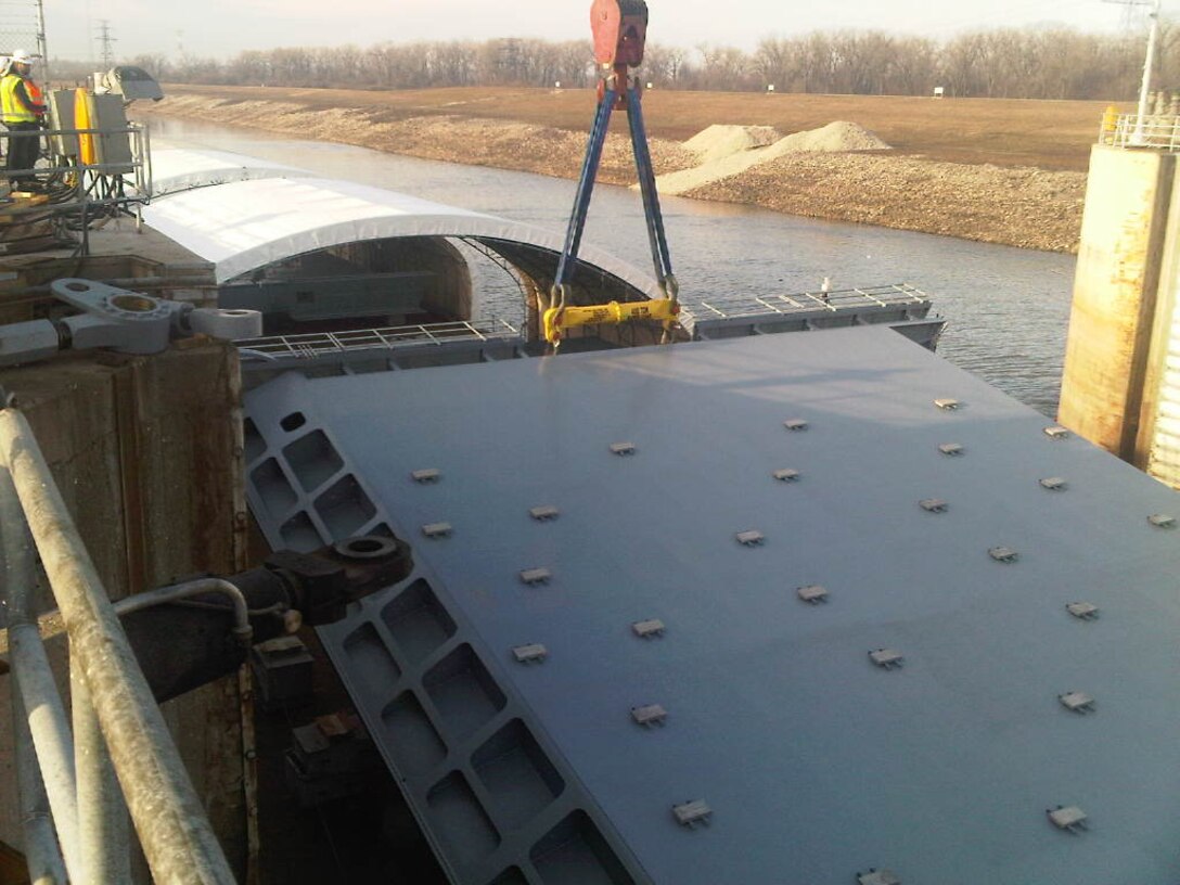 Massman construction, subcontractor for G&G Steel, lifts the new miter gates for Lock 27's main chamber from the laid down position to the standing position.  G&G steel fabricated the gates.  The gate weighs over 500,000 lbs with the turning feet and crane rigging attached.