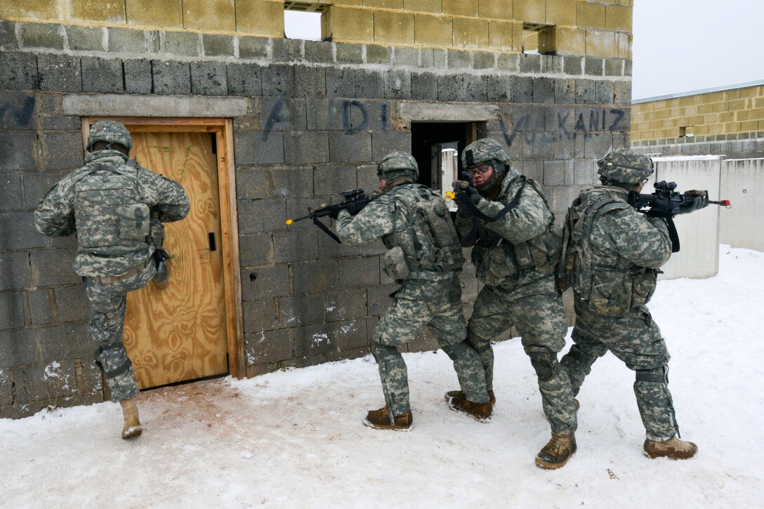 U.S. soldiers break through a door as part of building clearing practice during squad training at the Grafenwoehr Training Area, Germany, Feb. 13, 2013.