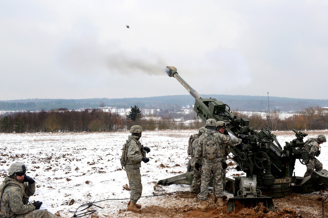 U.S. soldiers fire an M777A2 howitzer round down range during a ...