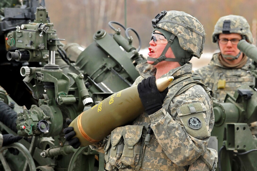 A U.S. soldier carries a round to load into an M777A2 howitzer during a rehearsal exercise at Grafenwoehr Training Area, Germany, Feb. 13, 2013. The soldiers are assigned to Field Artillery Squadron, 2nd Cavalry Regiment.