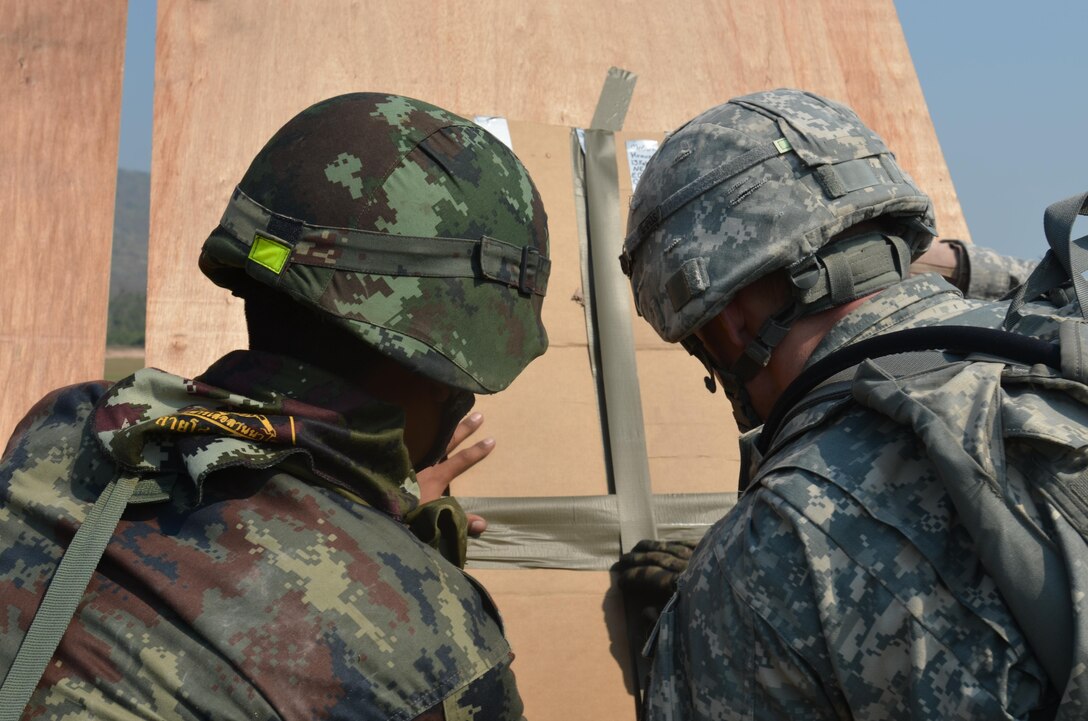 A Royal Thai Army soldier, left, and a U.S. Army soldier attach a detonation device to primer cord on a target Feb. 13 during live-fire explosive ordnance training at Camp Borokthai in Phitsanulok province, Kingdom of Thailand, during the field training portion of exercise Cobra Gold 2013. U.S. involvement in CG 13 demonstrates commitment to building military-to-military interoperability with participating nations and to supporting peace and stability in the region. The Thai soldier is with the 104th Heavy Artillery Unit, RTA, and the U.S. soldiers are with 319th Explosive Ordnance Disposal Company, 96th Troop Command.