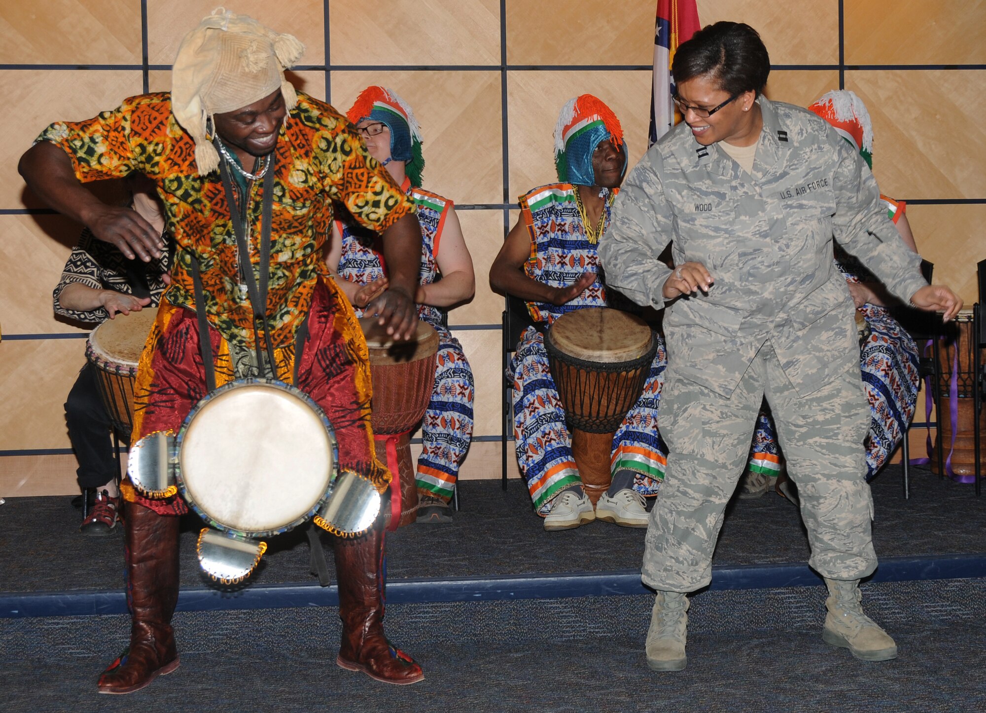 Capt. Danielle Wood, 188th Equal Opportunity officer, right, dances with a member of Afrique Aya, a troupe of drummers and dancers, during a performance at the 188th Fighter Wing during a Black History Month celebration held at the Hugh B. Correll Headquarters building Feb. 3. The group performed rhythms inspired by the music and culture of West Africa. (National Guard photo by Airman 1st Class Cody Martin/188th Fighter Wing Public Affairs)