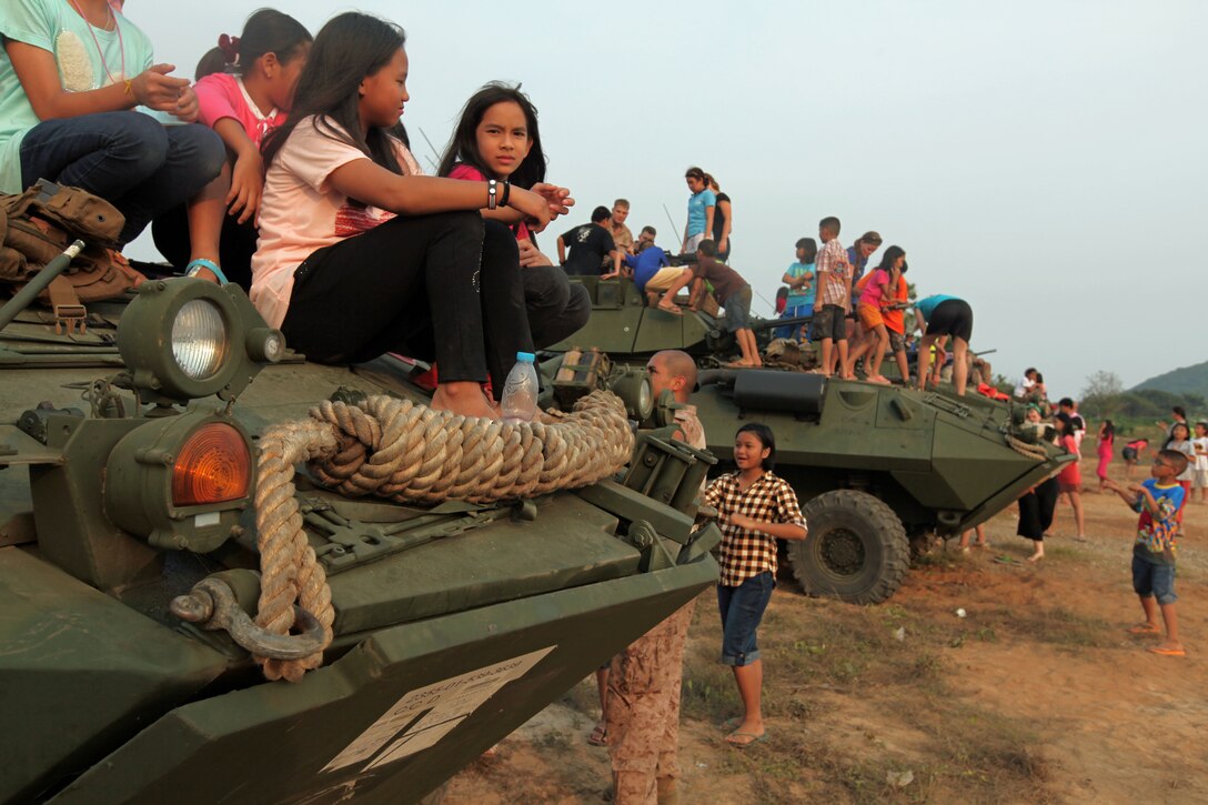 Children of the Wat Don Thong School climb on vehicles provided by the Marines and Sailors of Weapons Co., Battalion Landing Team 1st Battalion, 5th Marine Regiment, 31st Marine Expeditionary Unit, here, Feb. 15. More than one hundred children from the school in Chachoengsao came to visit with the Marines and practice their english speaking skills. The Marines set up a display of four light armored vehicles and one high mobility, multipurpose wheeled vehicle (HMMWV) for the children to explore. 