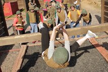 Milaca High School teacher Colleen Bell shimmies up one of the 12 Stall obstacles at Camp Pendleton Jan. 31. Educators had the opportunity to complete the same obstacles recruits encounter during the Crucible. For additional imagery from the event, visit www.facebook.com/rstwincities.