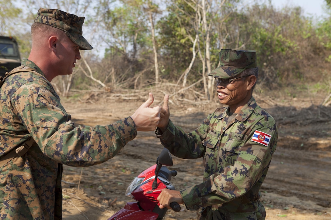 U.S. Marine Capt. T. Grayson Ernst, left, and Royal Thai Marine Lt. Cmdr. Telone Tutason give each other an international sign of approval Feb. 14 near the base camp of Combat Assault Battalion in Ban Chan Krem, Kingdom of Thailand. The camp is dubbed â€œCamp Ivoryâ€ on account of recently sighted elephants in the area. Thai and U.S. Marines are conducting field training exercises from Feb. 11 to 22 for exercise Cobra Gold 2013, which is a multinational exercise that promotes regional prosperity, security and cooperation among partner militaries. Tutason is the commandant of Camp BCK, and Ernst is a combat engineer officer and current operations director for CAB, 4th Marine Regiment, 3rd Marine Division, III Marine Expeditionary Force.
