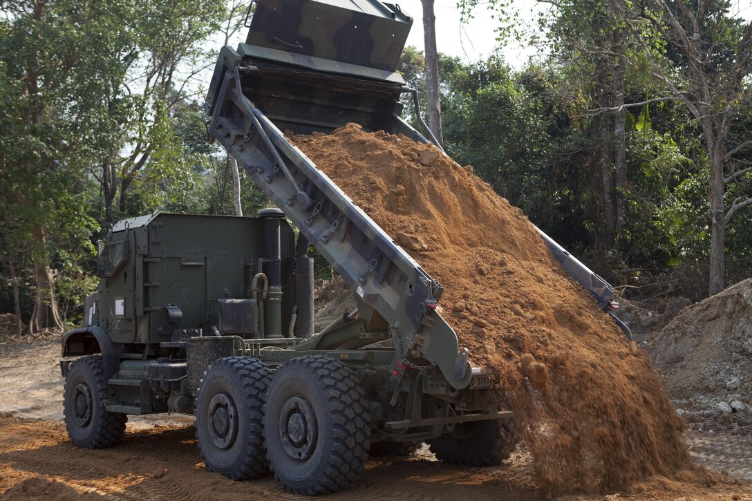 U.S. Marine Corps engineer equipment operators dump a layer of dirt onto a newly excavated road Feb. 14 at Ban Chan Krem, Kingdom of Thailand. The road construction is part of field training during exercise Cobra Gold 2013 and future expansion of the training range at Ban Chan Krem. Cobra Gold is a recurring, multinational and multiservice exercise hosted annually by Thailand and developed by the Thai and U.S. militaries. The engineers are with Combat Assault Battalion, 4th Marine Regiment, 3rd Marine Division, III Marine Expeditionary Force.