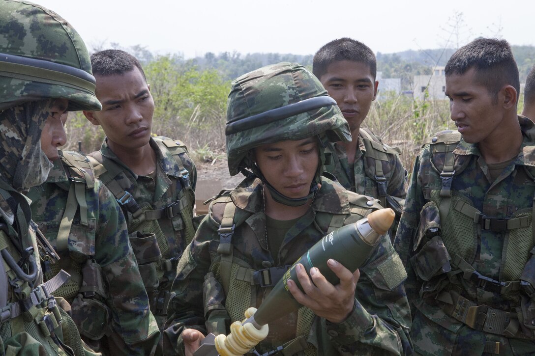 Royal Thai Marine Seaman Chaimongkon Pangtaisong, center, and members of his unit examine an 81mm mortar round Feb. 12 during the Cobra Gold 2013 field training exercises with U.S. Marines in Ban Chan Krem, Kingdom of Thailand. CG 13 is the largest multinational exercise in the Asia-Pacific region and provides all participating nations an opportunity to maintain relationships and enhance interoperability. Pangtaisong is a new member of the Royal Thai Marines and has been training to be a gunner for the 81mm mortar section, 3rd Battalion, 1st Infantry.